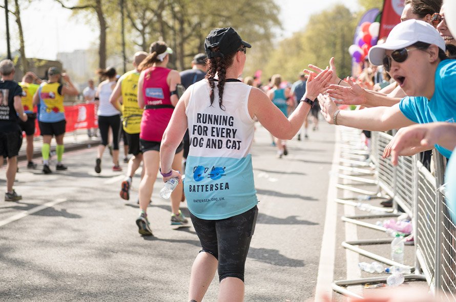 A runner high fiving supporters 