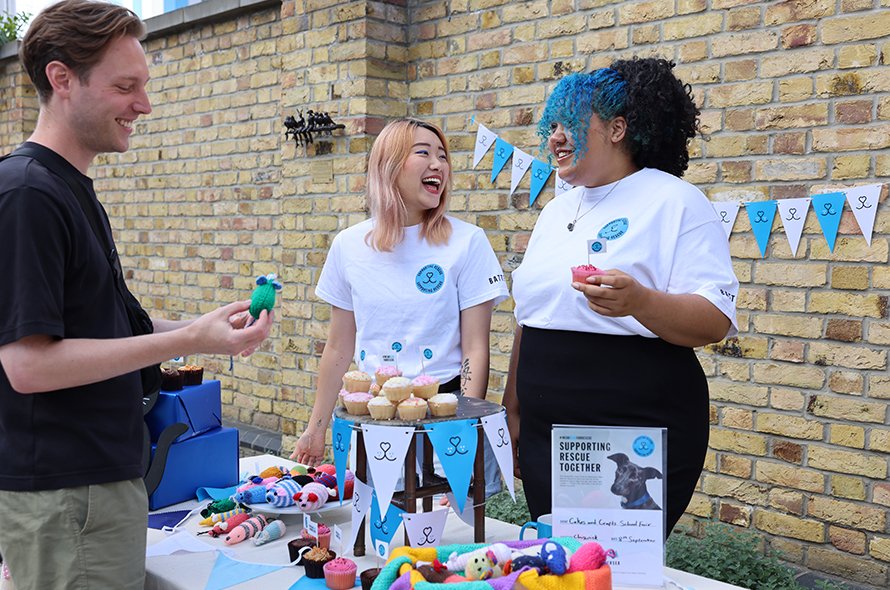 A small group of people chatting at a market stall