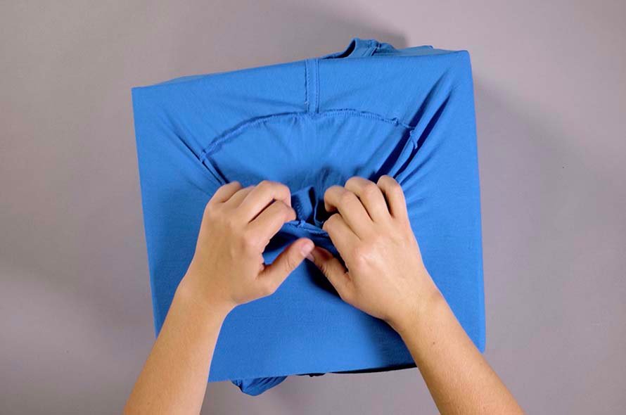 T-shirt being adjusted over cardboard box
