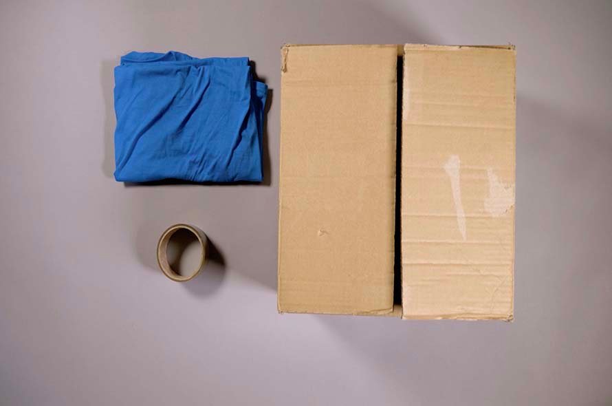 A cat hideaway made using a t-shirt and a cardboard box