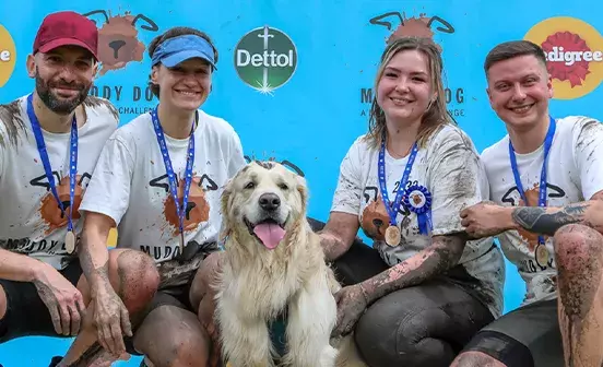 A group of people smiling with a dog