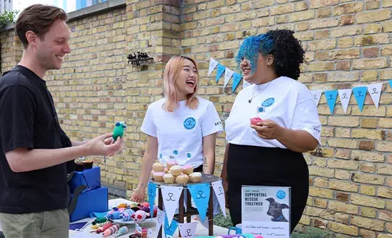 A small group of people chatting at a market stall