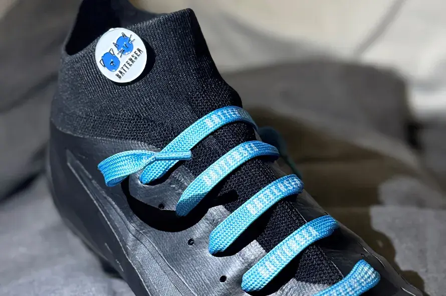 A football boot with Battersea laces and a Battersea badge