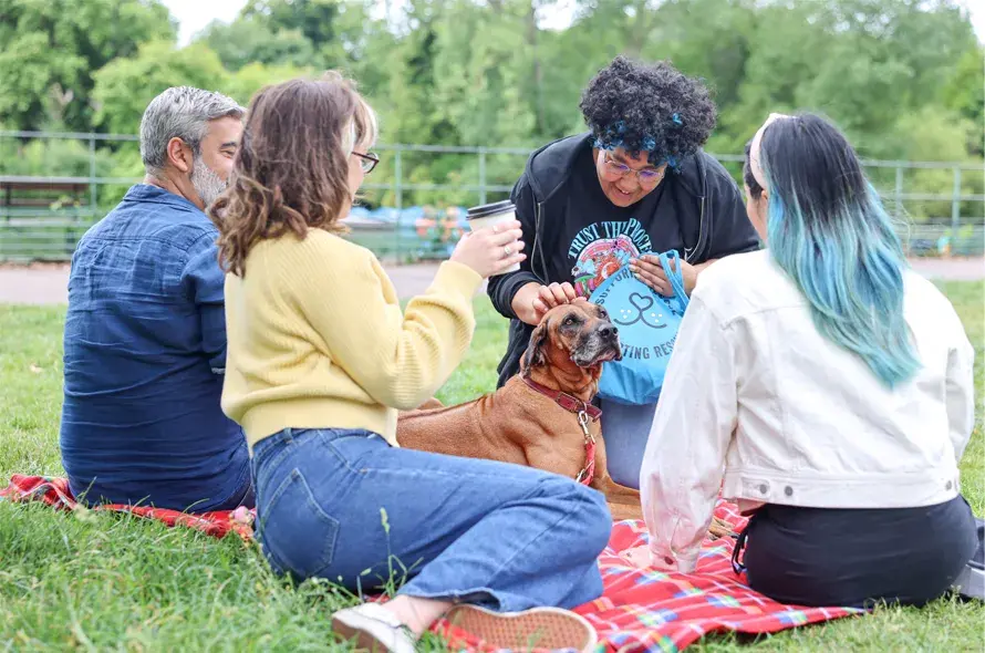  A small group with a dog at a picnic.
