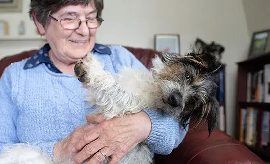 Ex-Battersea dog Tess in the arms of her new owner